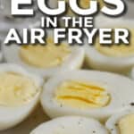 sliced hard boiled eggs in the air fryer on a pate with text