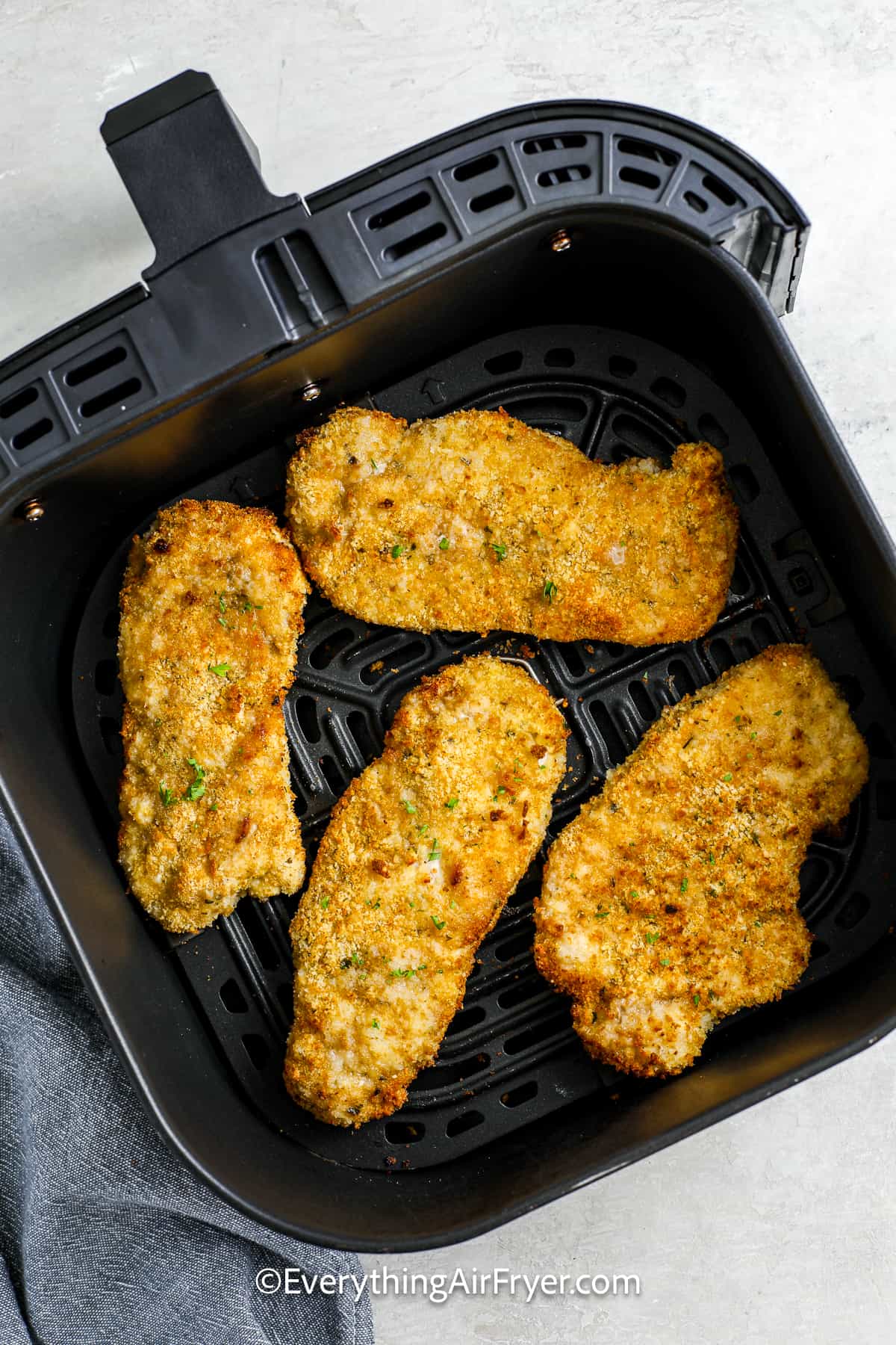 breaded pork chops cooked in an air fryer basket