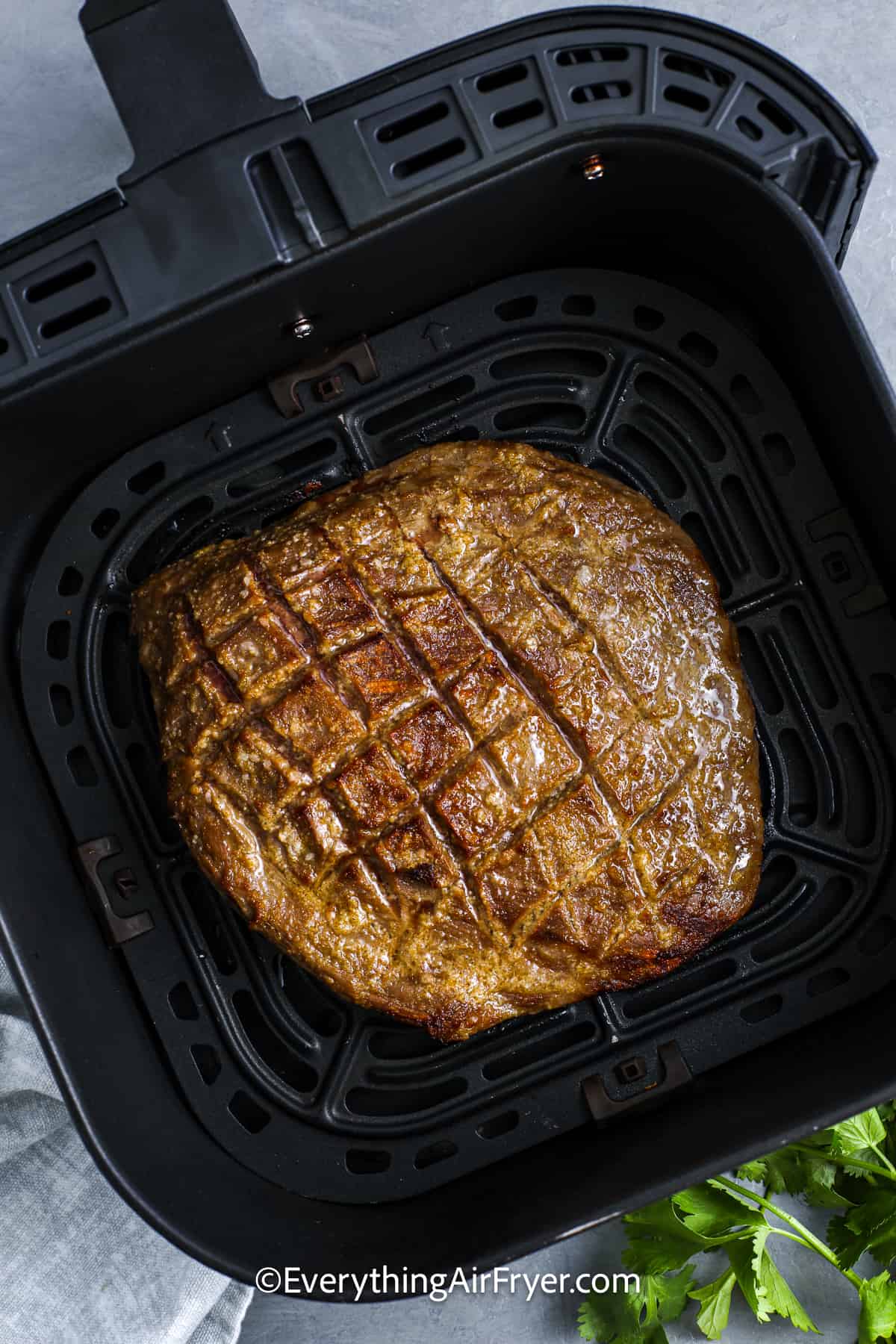 A cooked Flank Steak in an air fryer basket