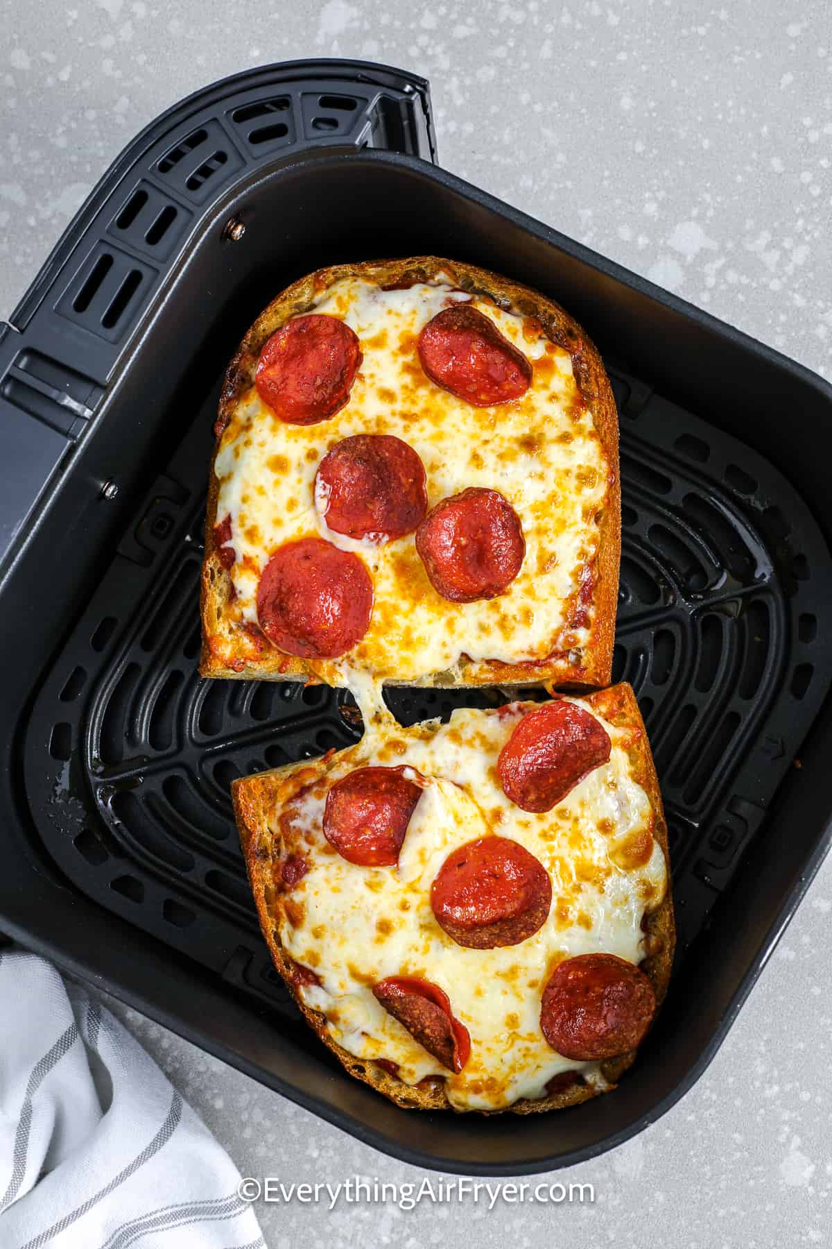 toasted air fryer french bread pizza in an air fryer tray