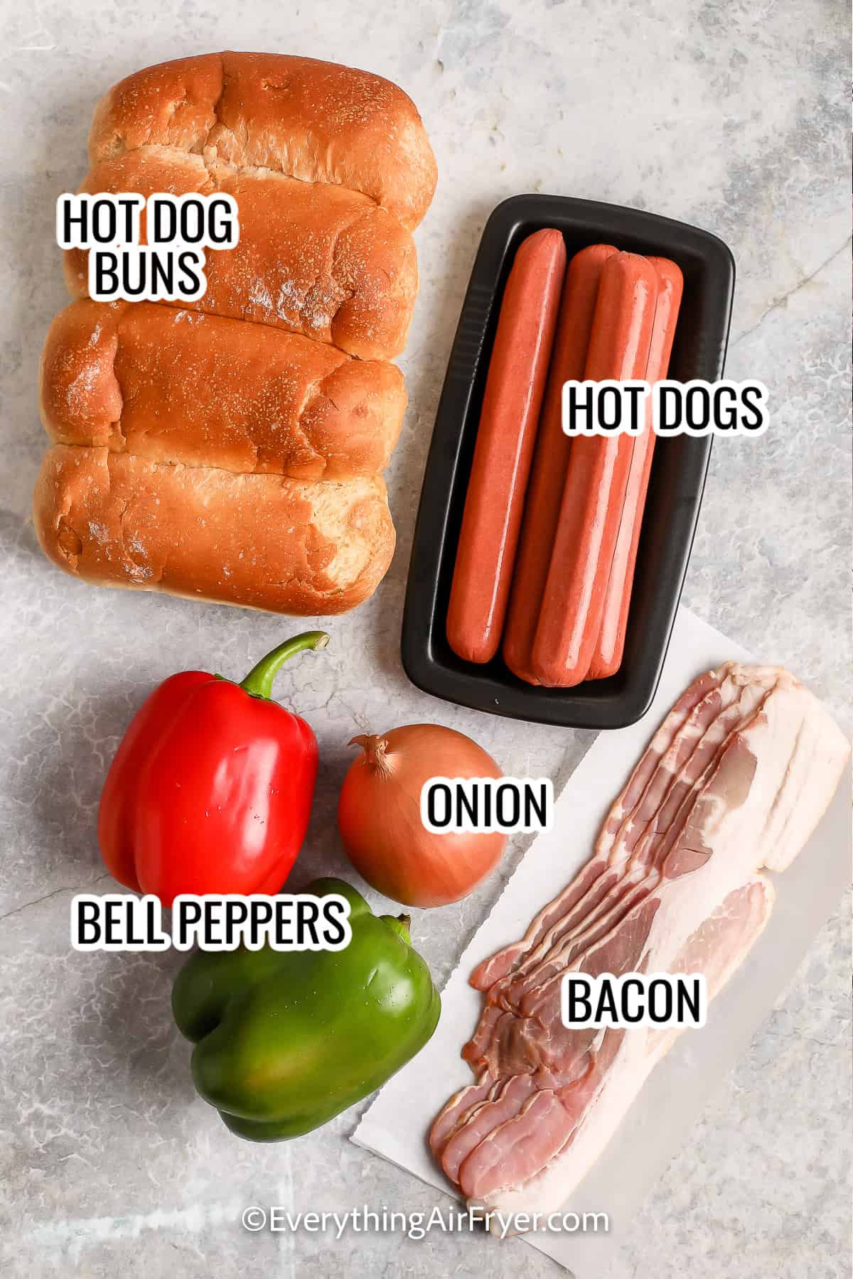 ingredients assembled to make air fryer LA hot dogs including hot dog buns, hot dogs, bell peppers, onion, and bacon