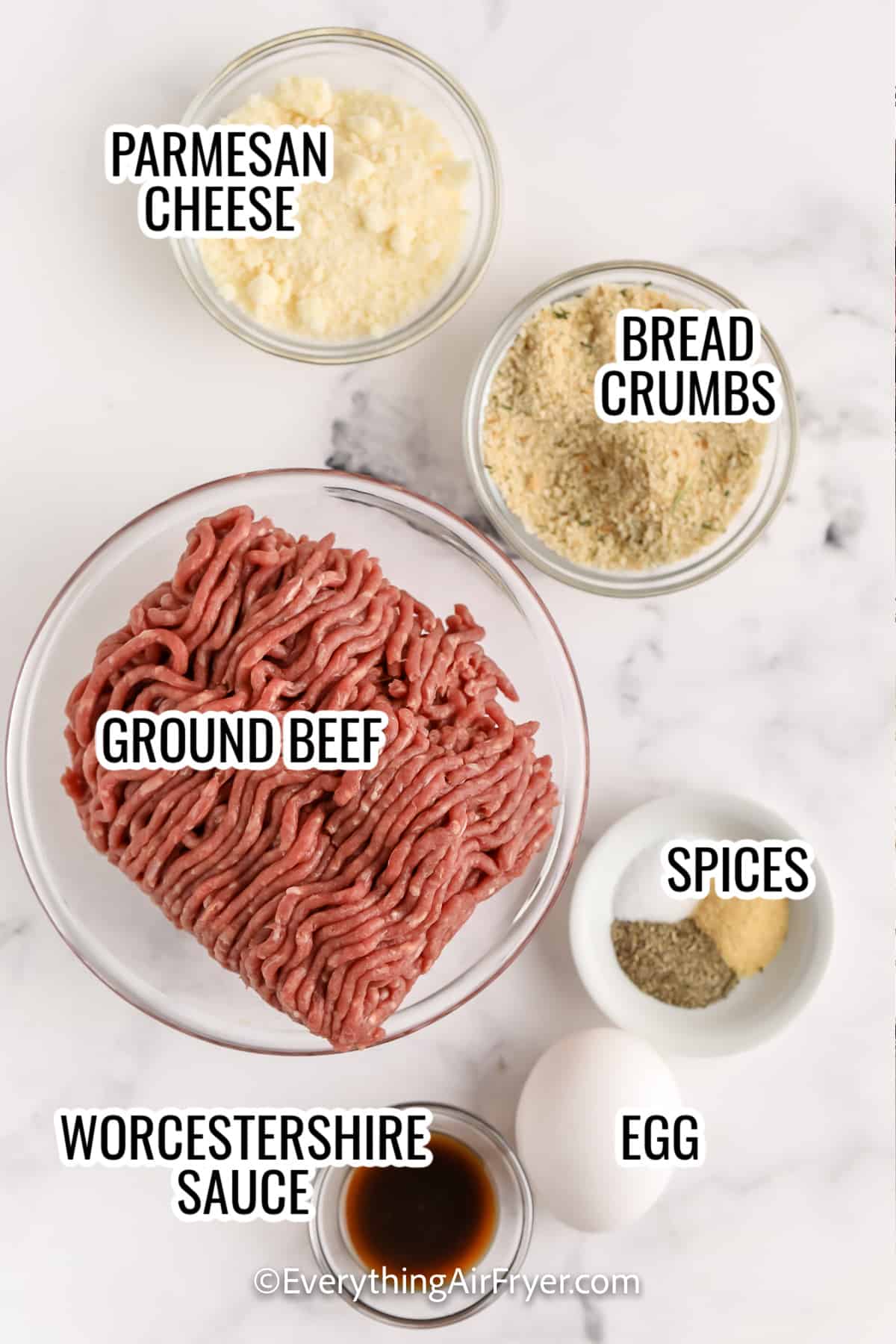 ingredients assembled to make homemade air fryer meatballs including ground beef, parmesan cheese, bread crumbs, spices, worcestershire sauce, and an egg
