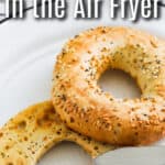Air fryer toasted bagel on a plate with butter being spread on top with text