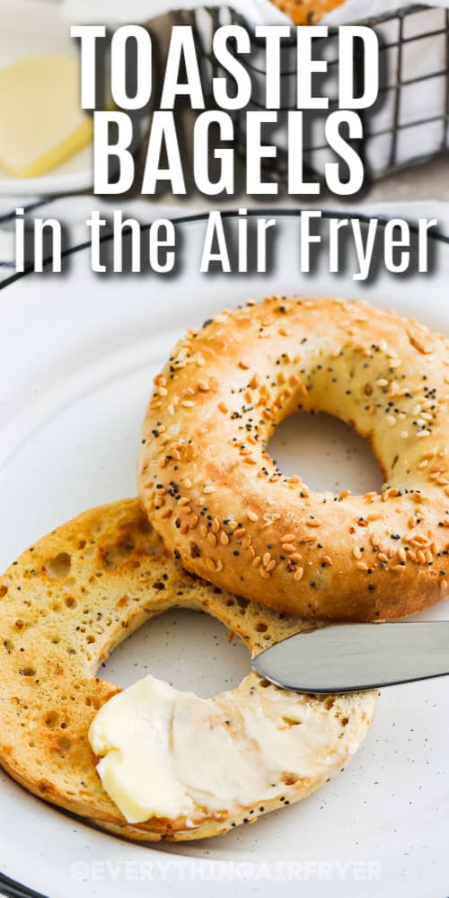 Air fryer toasted bagel on a plate with butter being spread on top with text